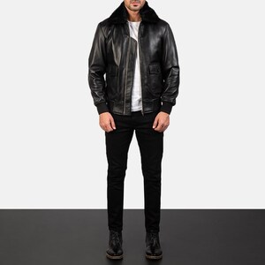 May include: A black leather bomber jacket with a fur collar. The jacket has a zipper closure and two pockets.