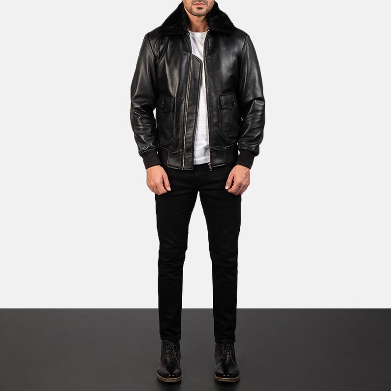 May include: A black leather bomber jacket with a fur collar. The jacket has a zipper closure and two pockets.