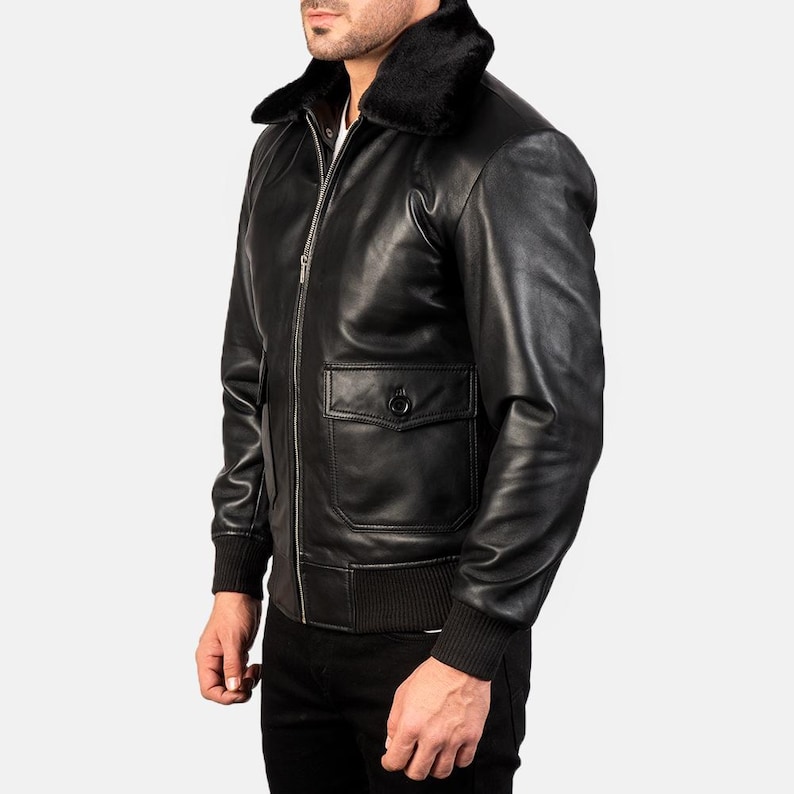 May include: A black leather bomber jacket with a faux fur collar and ribbed knit cuffs. The jacket has a zipper closure and a flap pocket on the left side.