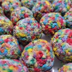 May include: Close-up of colorful, textured seed balls. Each ball is made of recycled paper and contains a variety of wildflower seeds.