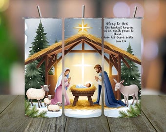 May include: A stainless steel tumbler featuring a Nativity scene with Mary, Joseph, and baby Jesus in a manger. The design includes a star, sheep, and the text "glory to God...Luke 2:14". The tumbler has a silver straw.
