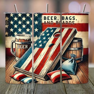 Puede incluir: Un juego de tres vasos de acero inoxidable de 20 oz con un tema patriótico. Los vasos presentan un diseño de bandera estadounidense con una jarra de cerveza, tablas de cornhole y bolsas de frijoles. El texto "Beer, Bags, and Boards" está impreso en los vasos.