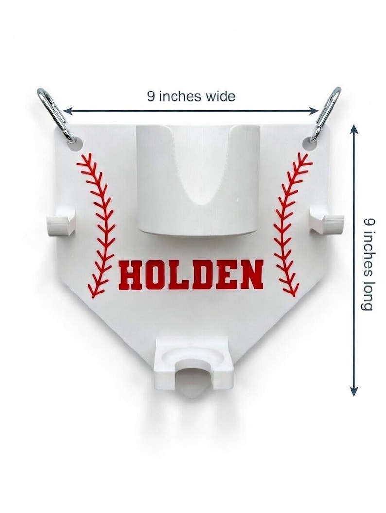 Pu&ograve; includere: Supporto a tema baseball bianco, largo e lungo 23 cm, con dettagli di cuciture rosse e il nome "HOLDEN" in lettere rosse. Presenta un portabicchieri centrale e due supporti laterali, con moschettoni argentati nella parte superiore.