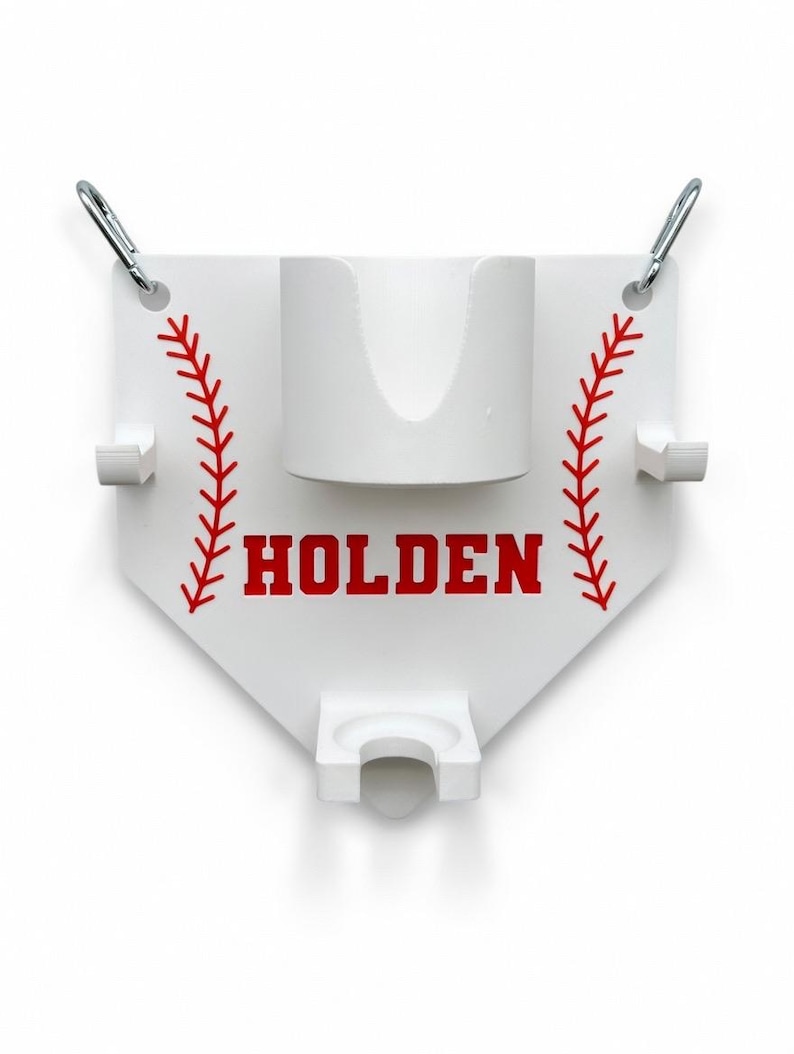 Pu&ograve; includere: Supporto bianco a tema baseball con cuciture rosse e il nome "HOLDEN" in lettere rosse. Presenta un portabicchieri e due ganci, con due moschettoni argentati nella parte superiore per appendere.