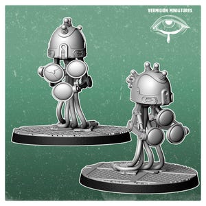 May include: Two grey miniature robot figures with dome-shaped heads, multiple thin legs, and three circular lens-like attachments on the front. Each figure stands on a circular base with a grid pattern. The text Vermilion Miniatures is visible.
