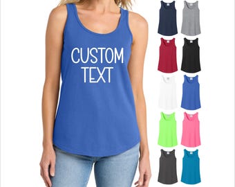 May include: A blue tank top with the words "CUSTOM TEXT" in white. The image also shows a variety of tank tops in different colors, including navy, gray, red, black, white, blue, green, pink, dark gray, and teal.
