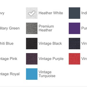May include: A color chart showing 14 different t-shirt colors. The colors are: Envy, Heather White, Indigo, Military Green, Premium Heather, Purple Rush, Tahiti Blue, Vintage Black, Vintage Navy, Vintage Pink, Vintage Purple, Vintage Red, Vintage Royal, and Vintage Turquoise.
