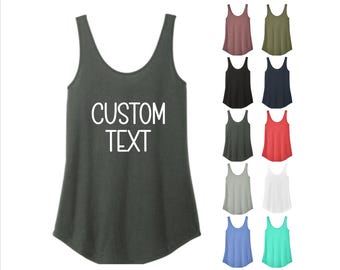 May include: A dark gray tank top with the words "CUSTOM TEXT" in white. The image also displays a variety of tank tops in different colors, including black, red, and blue. The tank tops have a scoop neck design.