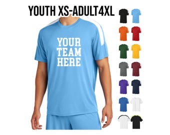 May include: A light blue performance t-shirt with white accents on the shoulders and sleeves. The shirt has the text "YOUR TEAM HERE" printed on the front in white. The shirt is available in a variety of colours, including black, orange, red, green, yellow, grey, maroon, purple, navy, white, and lime green.