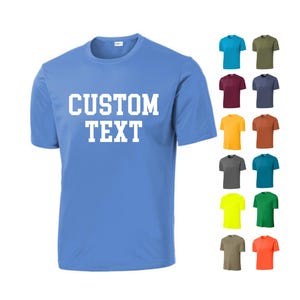 May include: A light blue t-shirt with the text "CUSTOM TEXT" printed in white on the front. The shirt is shown in a variety of colors, including red, green, yellow, and orange.
