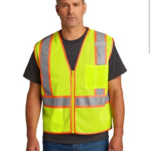 May include: A yellow safety vest with orange and silver reflective strips. The vest has a zipper closure and a mesh design.