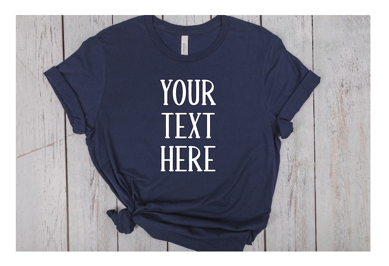 May include: A navy blue t-shirt with the text "YOUR TEXT HERE" printed in white on the front.