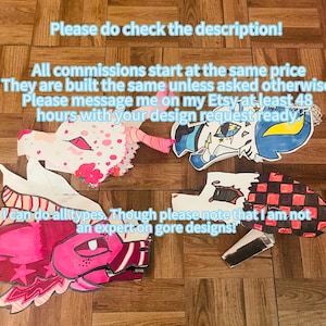 May include: Image showcasing paper dragon commissions with examples. The text reads "Paper dragon commissions!" and "Please do check the description!" Several colorful dragon head designs are displayed, with text indicating commission details and design requests.