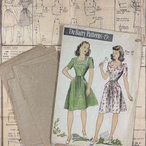 May include: A Du Barry sewing pattern envelope labeled 6071, size 12, bust 30, featuring illustrations of two dresses with square necklines and ruffled details. The set includes brown paper pattern pieces and a large instruction sheet with diagrams.