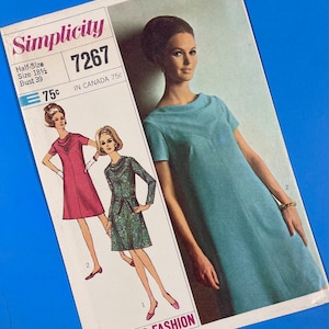 May include: Simplicity sewing pattern number 7267 for a half-size dress. The pattern includes three different dress styles, one with a blue dress, one with a pink dress, and one with a green dress. The pattern is for sizes 18 1/2 and bust 39. The pattern is 75 cents.