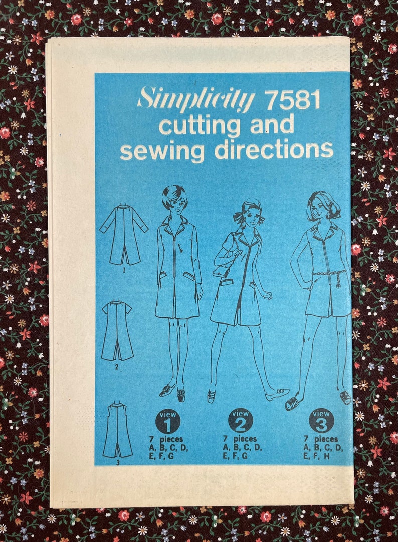 Puede incluir: Un patr&oacute;n de costura vintage Simplicity para un vestido, con tres vistas diferentes. El n&uacute;mero del patr&oacute;n es 7581. El patr&oacute;n est&aacute; impreso en un fondo azul con texto blanco e ilustraciones.
