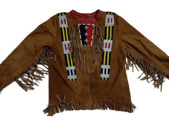 May include: Brown suede jacket with fringe detailing and colourful beaded trim. The jacket has a stand-up collar and long sleeves.
