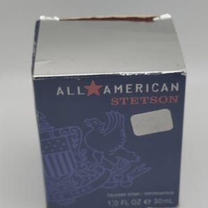 Peut inclure: Bo&icirc;te bleu marine avec un dessus en feuille d'argent. Le texte "ALL AMERICAN STETSON" est affich&eacute; avec une &eacute;toile rouge. La bo&icirc;te pr&eacute;sente un aigle et un bouclier. Le bas de la bo&icirc;te indique "1.0 FL OZ e 30ml".