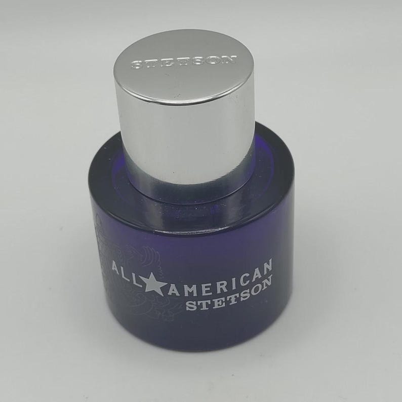 Peut inclure: Flacon de parfum Stetson bleu fonc&eacute; avec un bouchon argent&eacute;. Le flacon porte l'inscription "ALL AMERICAN STETSON" sur le devant. Le bouchon porte l'inscription "STETSON".