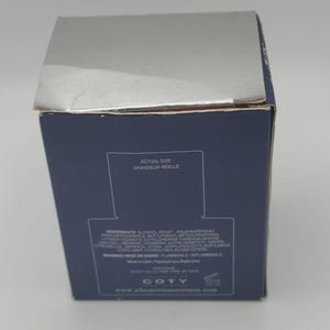 Peut inclure: Une bo&icirc;te de produit bleu marine avec un dessus argent&eacute;. La bo&icirc;te porte le texte "ACTUAL SIZE GRANDEUR REELLE" et des informations sur les ingr&eacute;dients. La marque "COTY" est visible au bas de la bo&icirc;te.