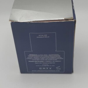 Peut inclure: Une bo&icirc;te de produit bleu marine avec du texte blanc, dont les mots "ACTUAL SIZE" et "GRANDEUR REELLE." La bo&icirc;te &eacute;num&egrave;re les ingr&eacute;dients et les avertissements. La marque "COTY" est visible en bas.