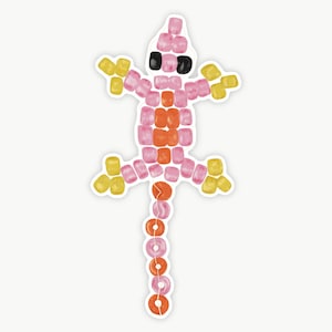 May include: A sticker of a lizard made of colorful beads. The lizard is primarily pink, orange, and yellow, with black eyes. The design is a playful, cartoon-like representation of a reptile.
