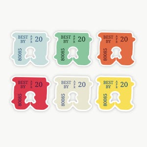 May include: Six plastic bread clips in light blue, green, orange, red, cream, and yellow. Each clip features the printed text BEST BY APR 20 and the number 80085. The clips have a central cutout and a notched design for securing bread bags.