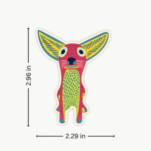 May include: A colorful sticker featuring a whimsical creature with large ears and wide eyes. The sticker is primarily red with yellow and blue accents. It measures 2.96 inches tall and 2.29 inches wide.