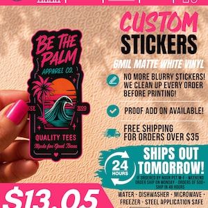 May include: A rectangular sticker with rounded corners featuring a black background, a pink palm tree, a teal ocean wave, and an orange sunset. The text reads BE THE PALM, APPAREL 02, QUALITY TEES, and script text. The sticker is held against a textured background.