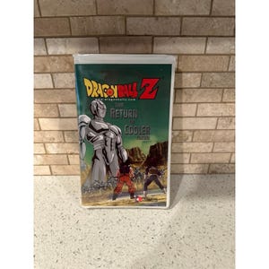 Op de afbeelding: Een Dragon Ball Z VHS-band met de titel The Return of Cooler. De hoes toont een groot, metallic zilveren personage dat boven een groep kleinere figuren staat, met Goku en Vegeta op de voorgrond tegen een rotsachtig landschap en groene lucht.