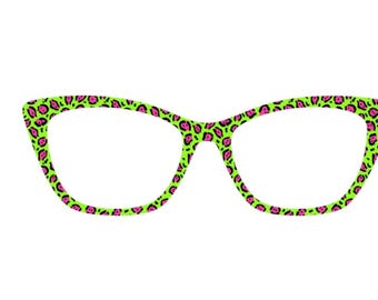 May include: A pair of cat-eye style eyeglasses with a neon green frame. The frame is decorated with a pink leopard print pattern. The lenses are clear, and the glasses are set against a white background.