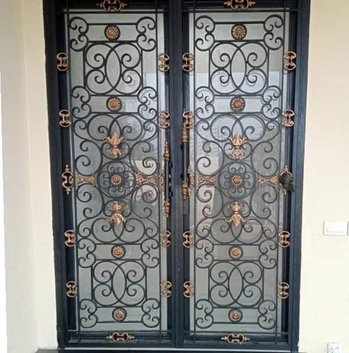 Handmade wrought iron double door with interlocking scrollwork and copper accent rosettes