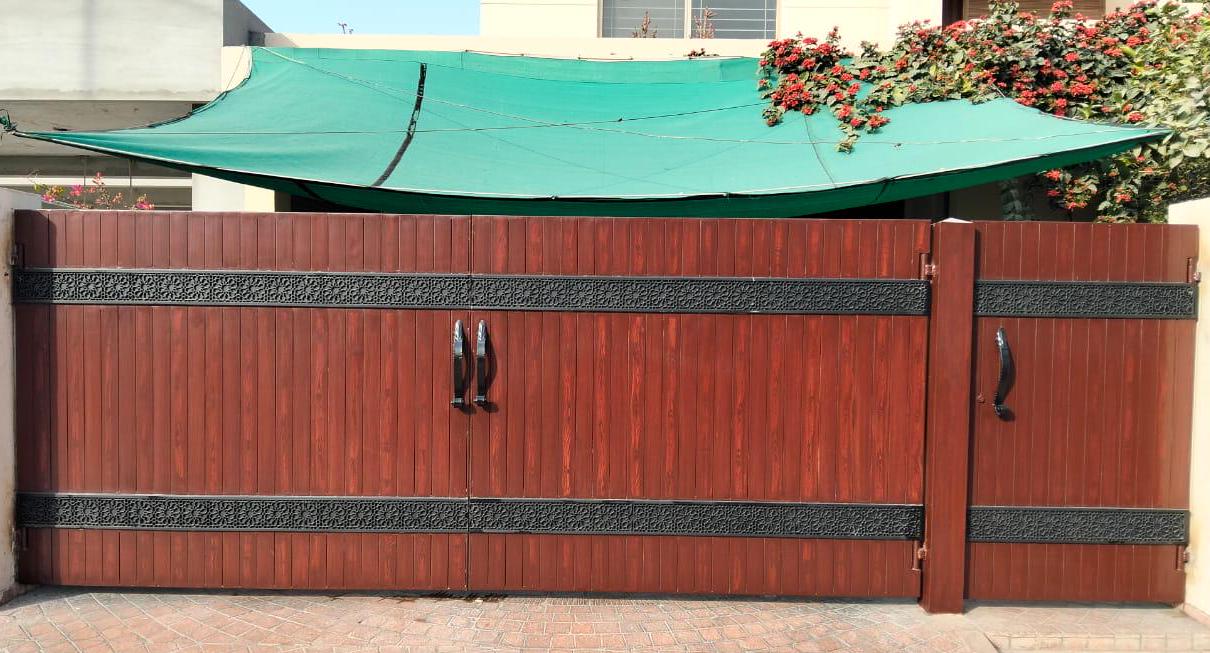 Handmade modern farmhouse driveway gate with wood-tone finish and decorative cast iron band