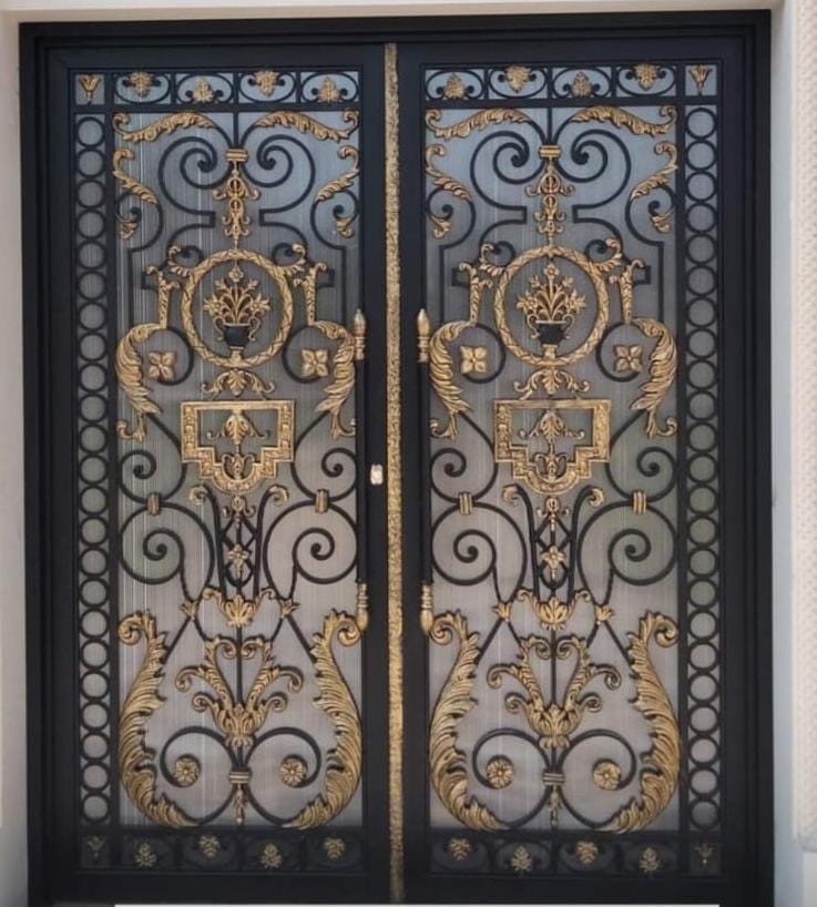 Handmade wrought iron double door with gold floral medallion and glass panel