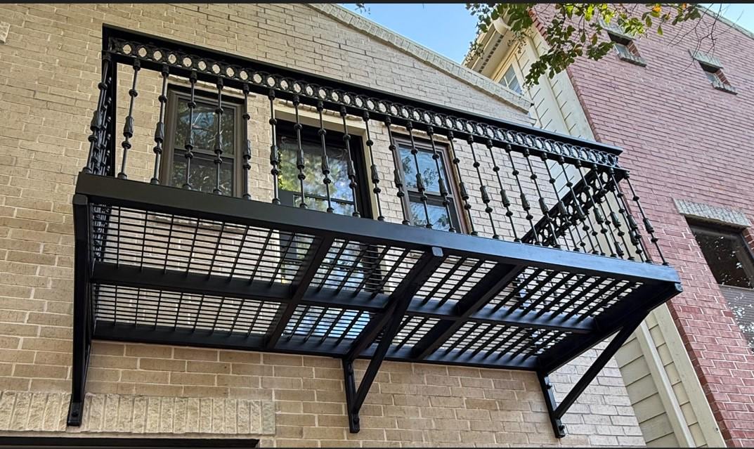 Handmade wrought iron Juliet balcony with mezzanine platform and rectangular vertical bar railing