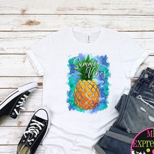 May include: White t-shirt with a watercolor pineapple design and the text "Summer Vibes".