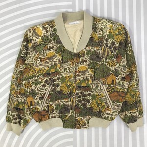 May include: A vintage bomber jacket with a rural landscape pattern in shades of green, brown, and yellow. The jacket has a beige collar, cuffs, and hem, with a zip-up front and two front pockets. The design is a unique and eye-catching piece.