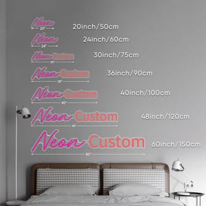 May include: Pink and orange neon signs with the text "Neon Custom" and "Neon" in various sizes, ranging from 50 cm to 150 cm. The signs are displayed against a grey wall above a bed.