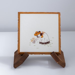 Sottopentola in legno e ceramica. Signora che raccoglie fiori