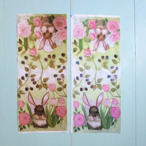 May include: Two rectangular fabric panels with a watercolor design. Each panel features a bunny surrounded by pink roses, tulips, and blackberries. The bunnies have long ears and are wearing a white bib. The background is a light green.