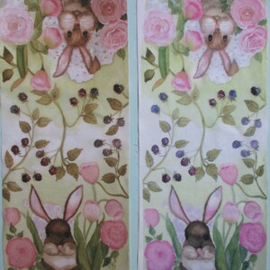May include: Two fabric panels with a watercolor design featuring bunnies, pink roses, tulips, and blackberries. The bunnies have long ears and are surrounded by flowers and foliage. The color palette includes shades of pink, green, and brown.