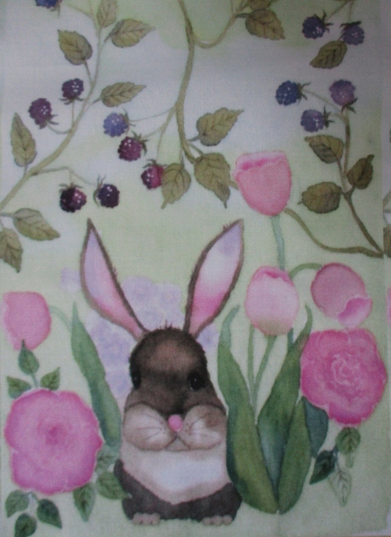 May include: Watercolor painting of a brown and white bunny with pink-lined ears, nestled among pink roses, tulips, and green foliage. Dark purple berries and leaves are scattered throughout the background. The overall theme is spring and nature.