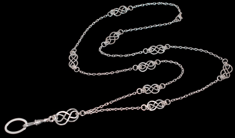 May include: Silver chain with a silver clasp and multiple silver infinity symbol charms.