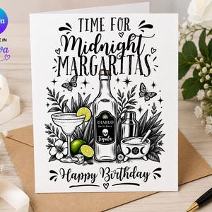 May include: A white greeting card featuring black line art of a tequila bottle labeled Diablo De la Rosa, a margarita glass with lime slices, a cocktail shaker, and a bowl. The text reads Time for Midnight Margaritas and Happy Birthday.