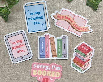 May include: A collection of colorful stickers with book-themed designs. The stickers include phrases like "in my reading era," "one more chapter," and "sorry, I'm booked." Other stickers depict stacks of books and a Kindle.