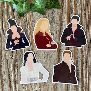 May include: Six illustrated stickers featuring characters from the television show Once Upon a Time. The stickers are white with a black outline and feature the characters Regina, Snow White, Captain Hook, Emma Swan, and Prince Charming.