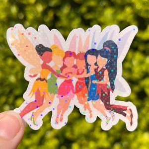 May include: A sticker featuring a group of six fairies with glitter accents. The fairies are depicted in various poses and wearing dresses in shades of yellow, green, pink, red, blue, and brown. The sticker has a white outline and a glittery effect.