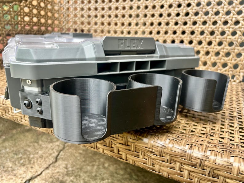 Peut inclure: Un organisateur de rangement en plastique gris avec un couvercle transparent et le mot FLEX en relief sur le loquet avant. Trois porte-gobelets cylindriques noirs &agrave; fa&ccedil;ade ouverte sont fix&eacute;s &agrave; l'avant par des vis m&eacute;talliques.