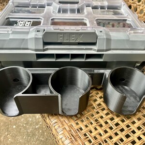 Peut inclure: Un organisateur de rangement en plastique gris avec un couvercle transparent et le mot FLEX en relief sur le loquet avant. Fix&eacute; &agrave; l'avant se trouve un accessoire porte-gobelet noir &agrave; trois emplacements avec des ouvertures lat&eacute;rales.