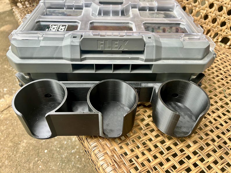 Peut inclure: Un organisateur de rangement en plastique gris avec un couvercle transparent et le mot FLEX en relief sur le loquet avant. Fix&eacute; &agrave; l'avant se trouve un accessoire porte-gobelet noir &agrave; trois emplacements avec des ouvertures lat&eacute;rales.